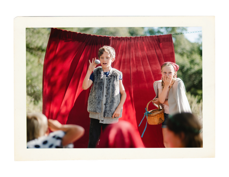 Children performing in front of a red curtain